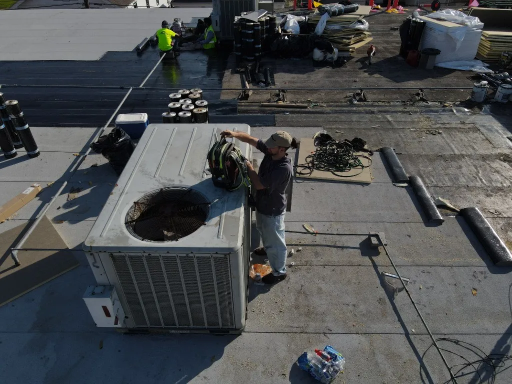 AC Maintenance technician servicing a rooftop HVAC unit